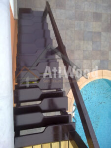 Escalera interior con peldaños de madera oscura a medida
